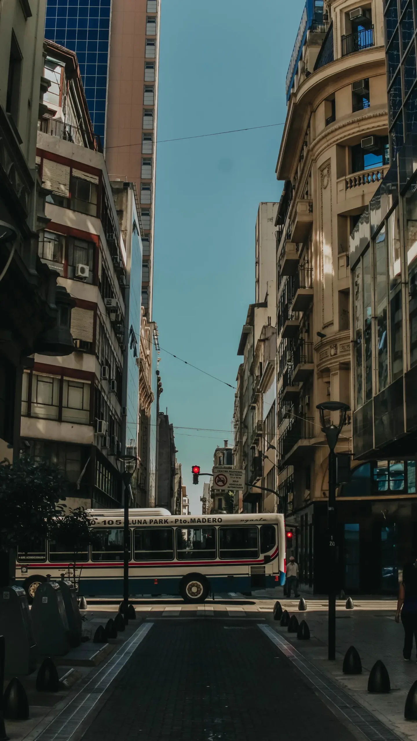 a bus driving down a street next to tall buildings