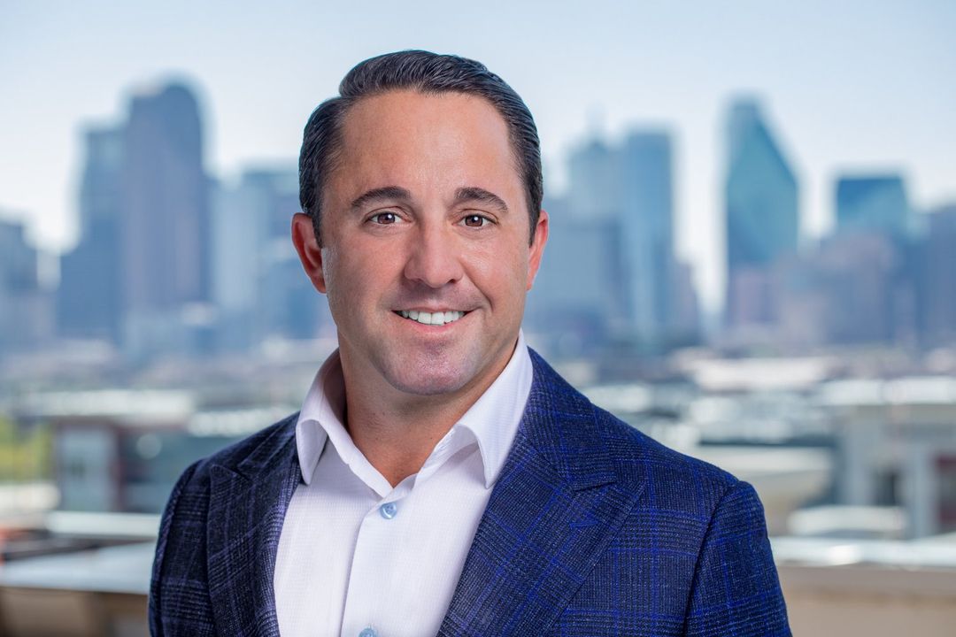 a man in a suit and tie standing in front of a city skyline
